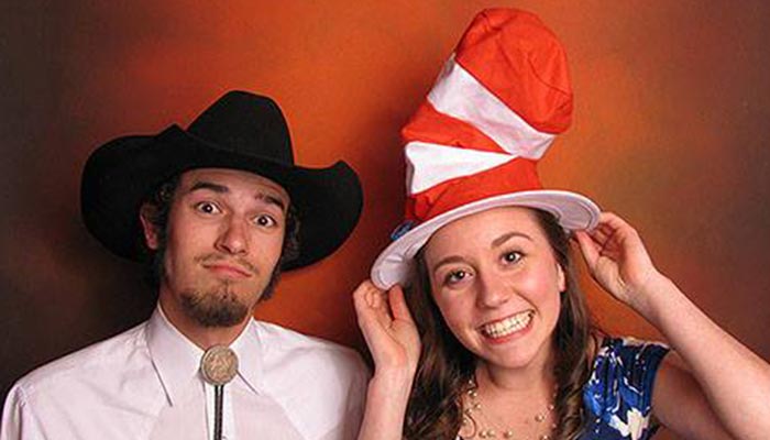 A man and woman wearing hats posing for the camera.