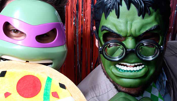A man in green costume and a purple mask.