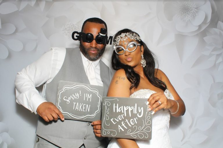 A man and woman posing for a photo booth.