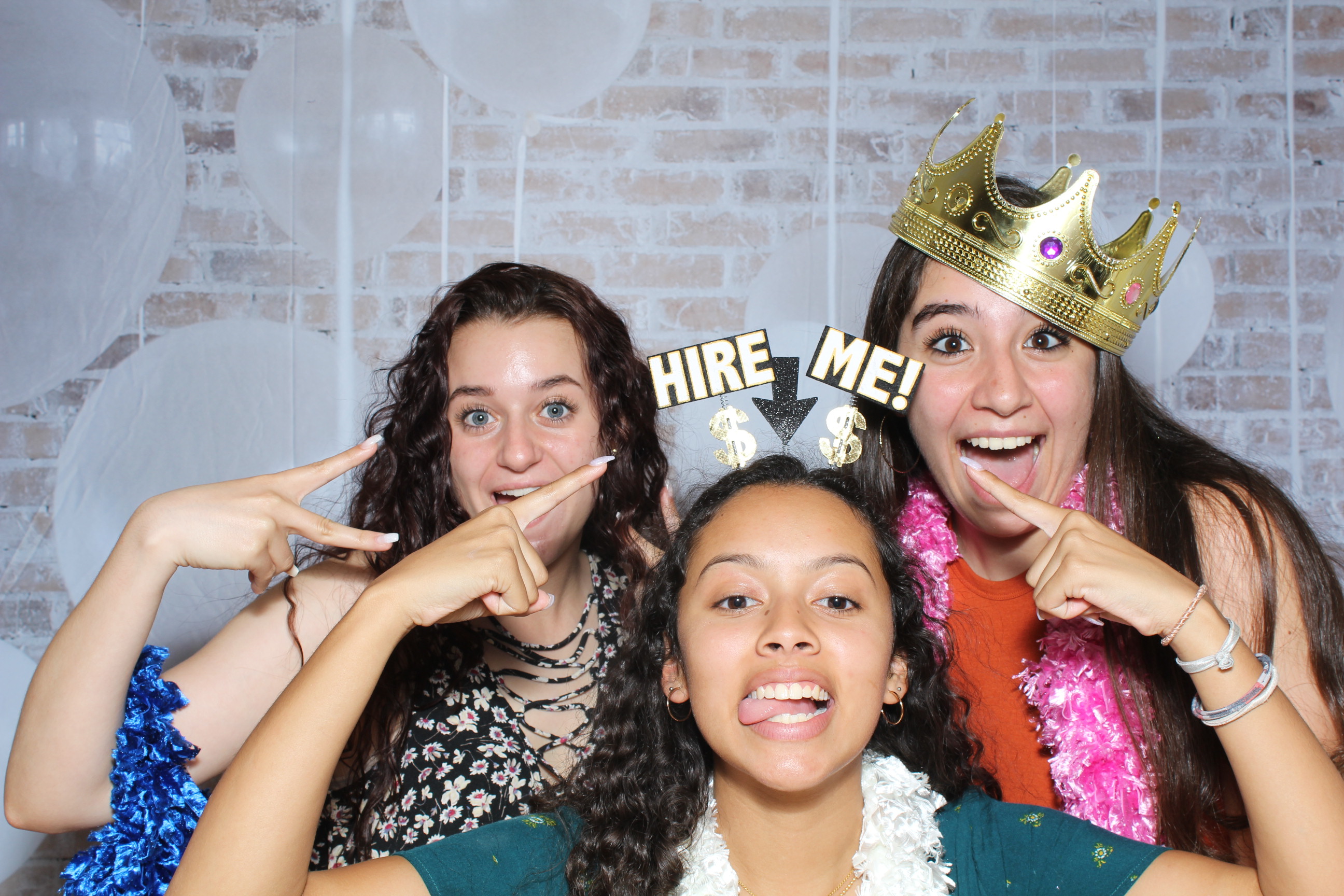 Three girls posing for a photo booth picture.