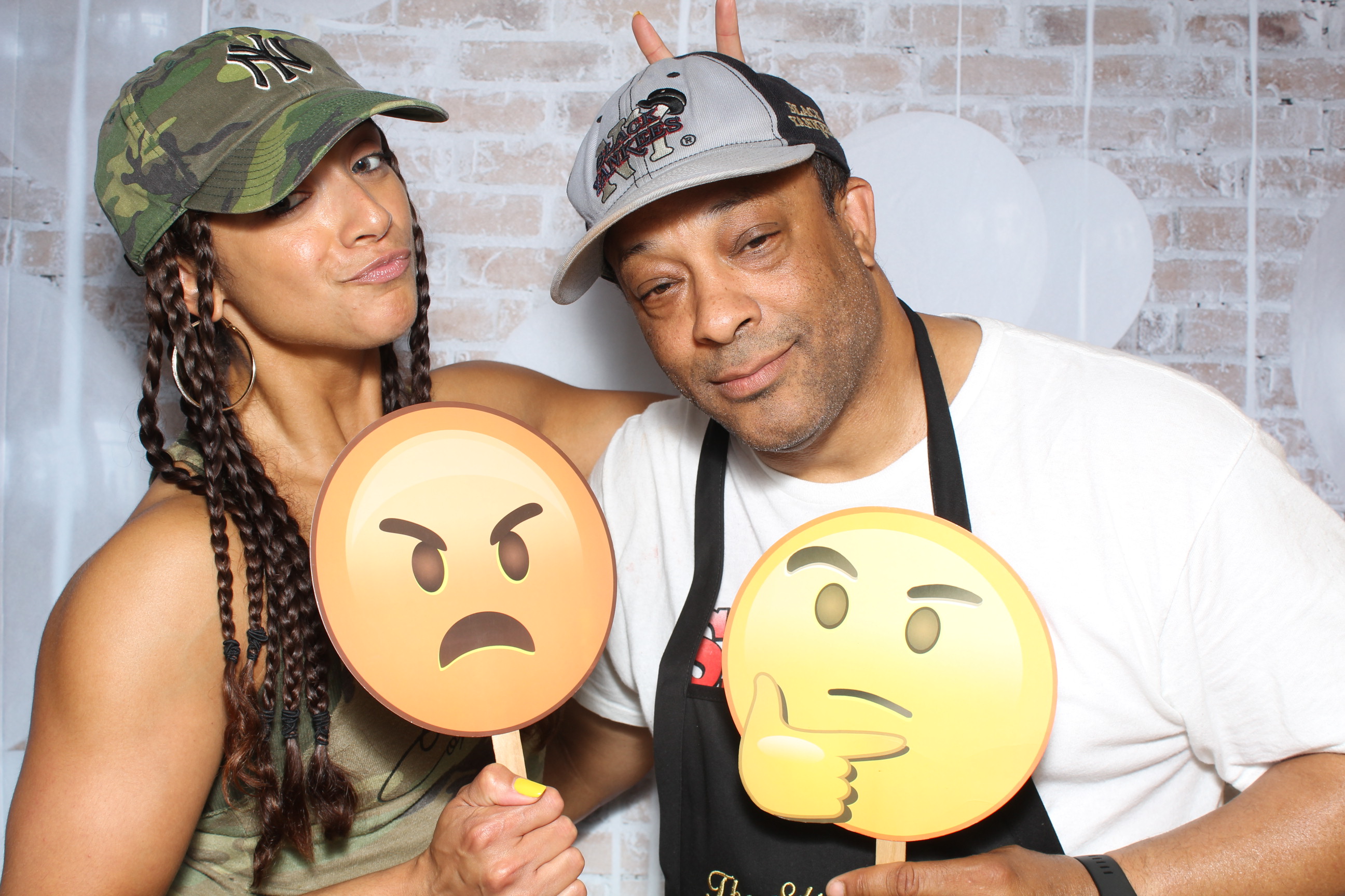 A man and woman holding angry faces on sticks.