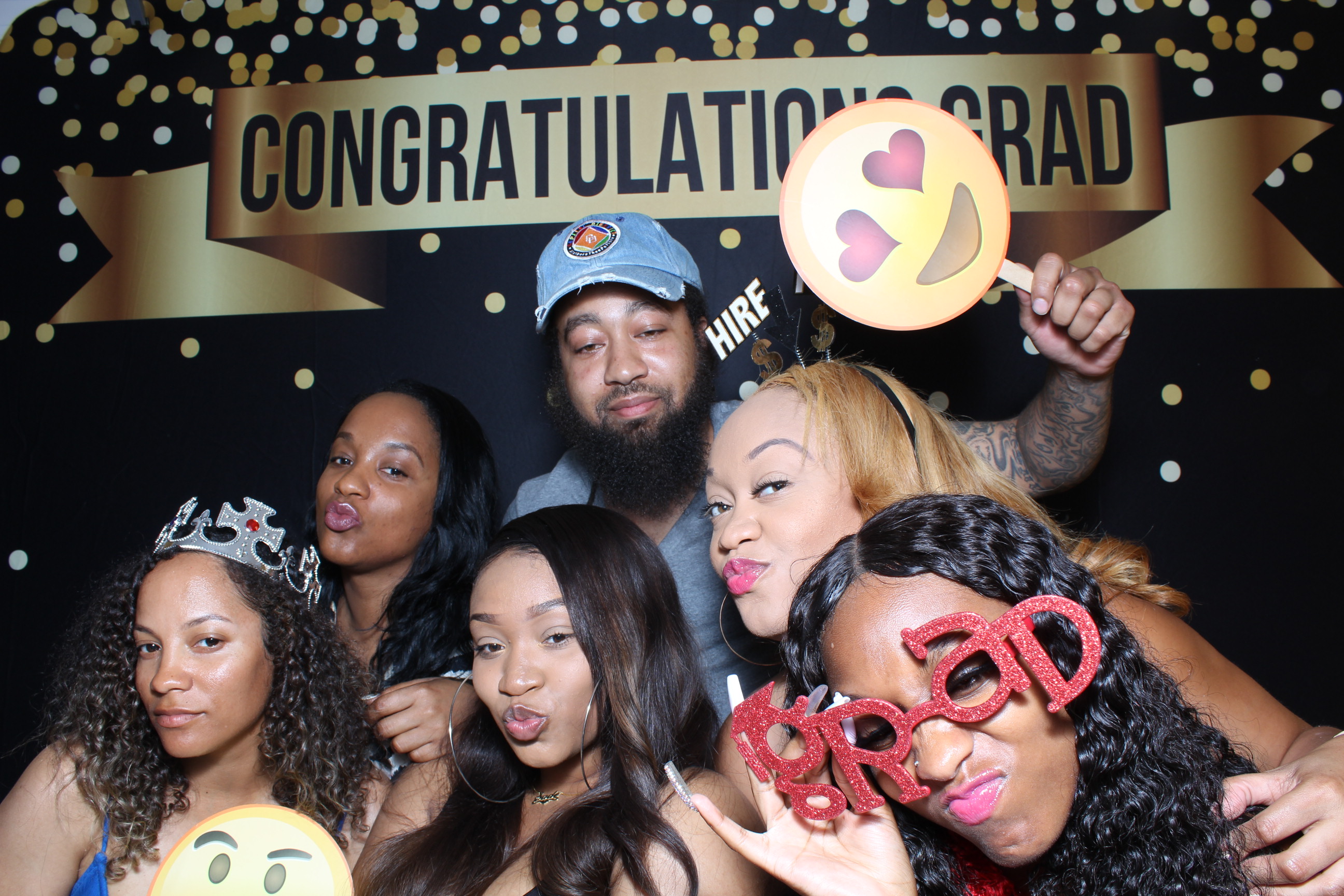 A group of people posing for a picture in front of a graduation sign.