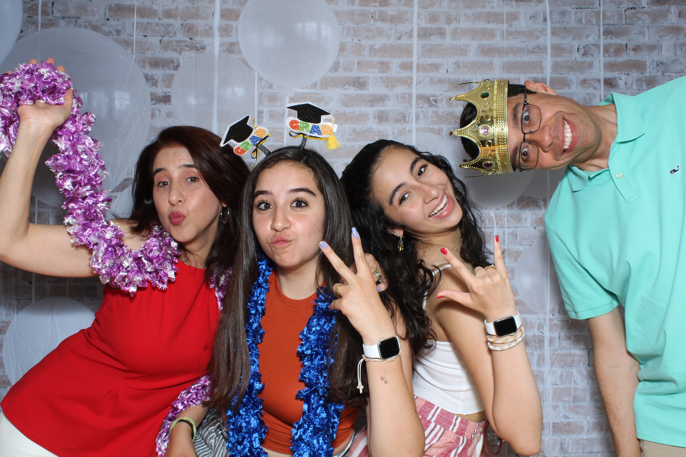 A group of people posing for the camera in front of balloons.