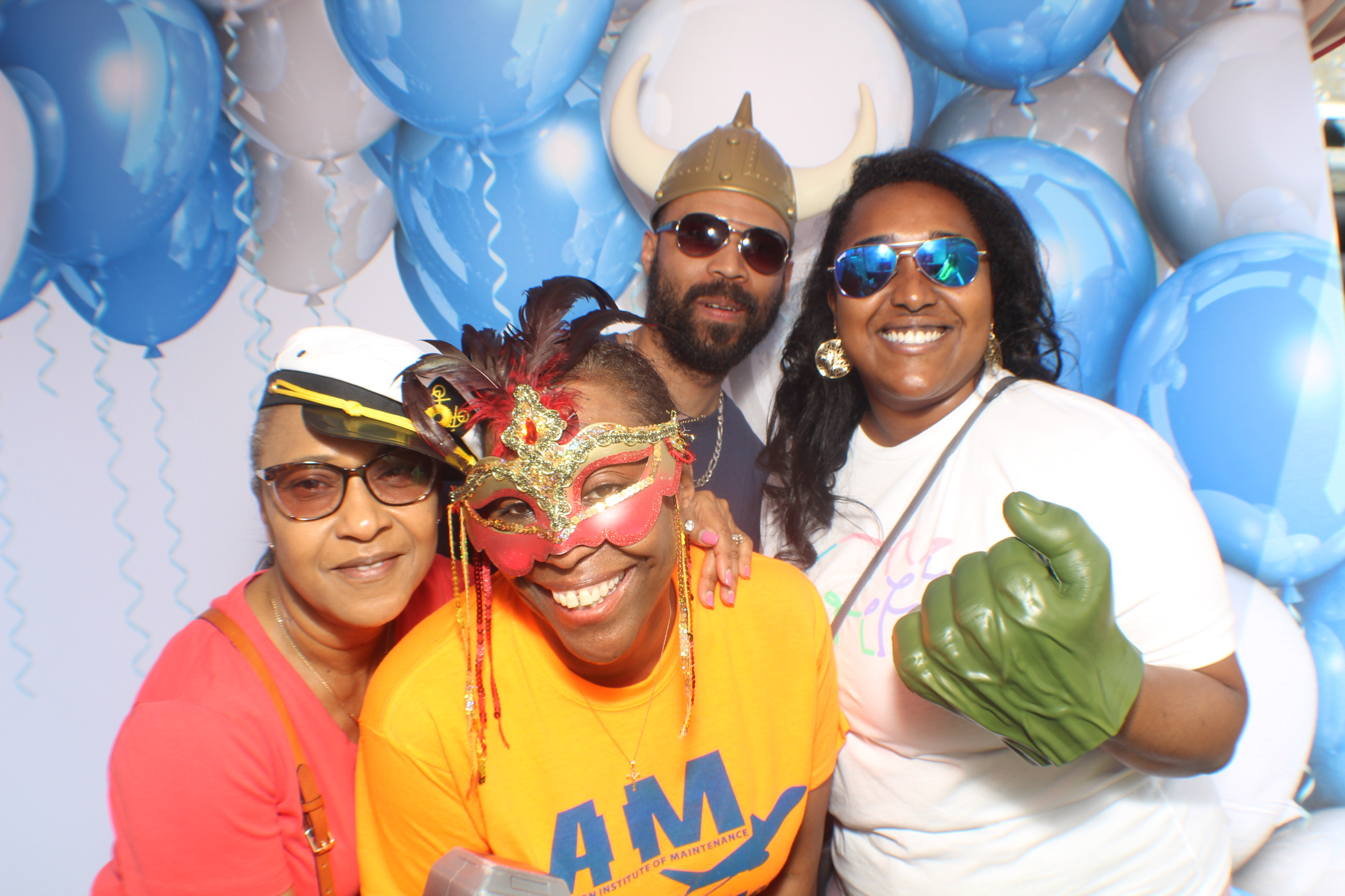 A group of people posing for the camera in front of balloons.