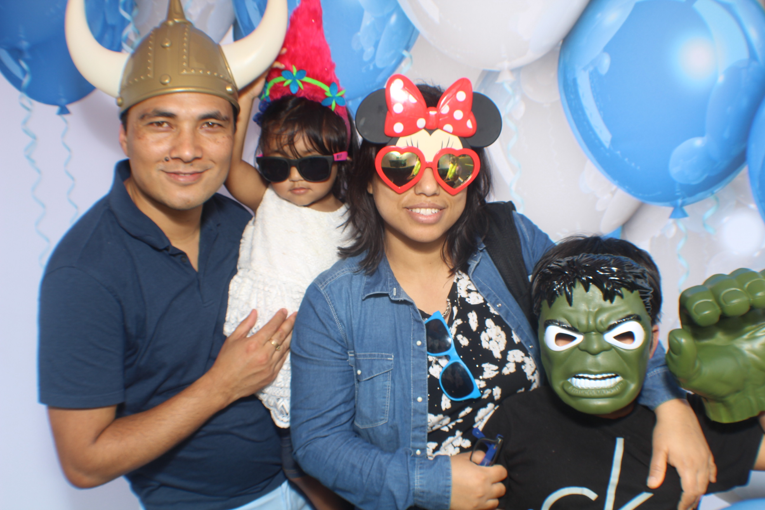 A family posing for the camera with balloons in the background.