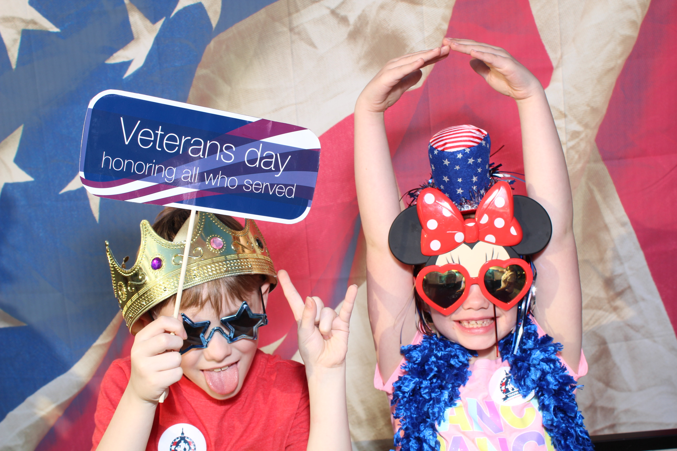 Two children wearing hats and glasses posing for a picture.