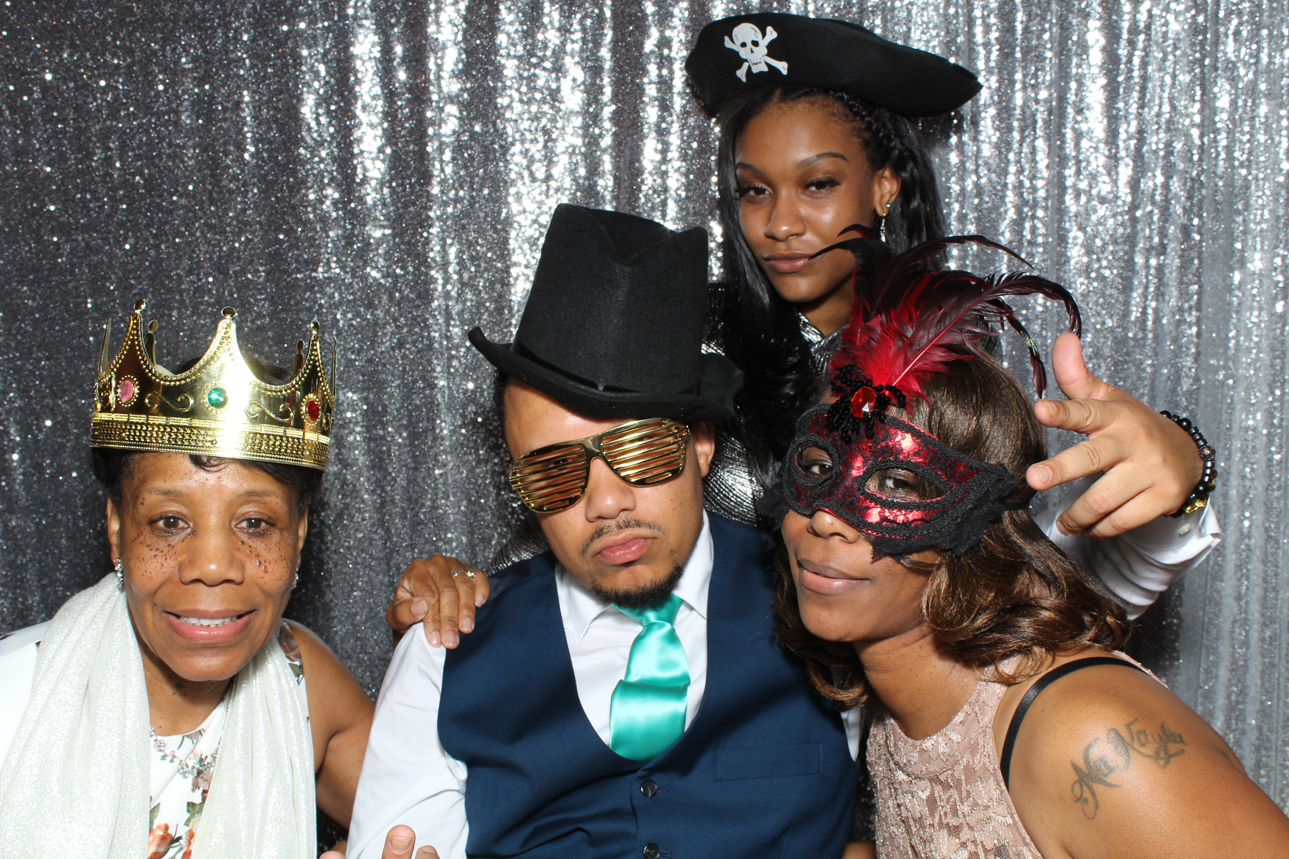 A group of people posing for the camera in front of a silver backdrop.