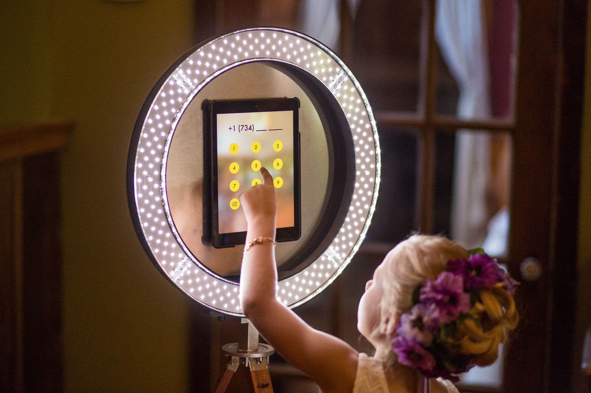 A woman is using the ring light to take pictures.
