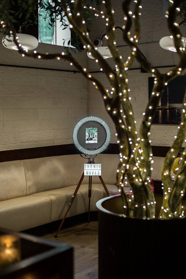 A photo booth with lights on the tree